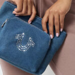 A Woman Holding True Religion Crystal Horseshoe Cosmetic Bag