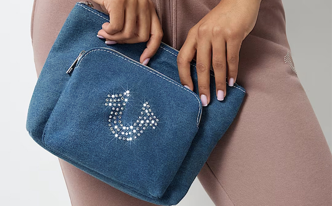 A Woman Holding True Religion Crystal Horseshoe Cosmetic Bag