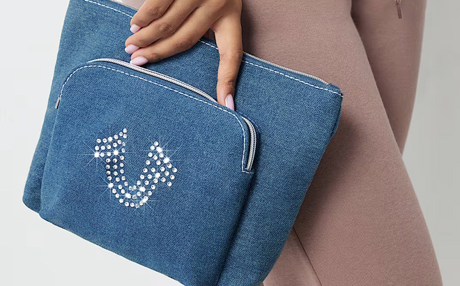 A Woman Holding a True Religion Crystal Horseshoe Cosmetic Bag