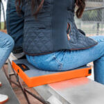 A Woman Sitting on the Thaw Rechargeable Heated Seat Pad