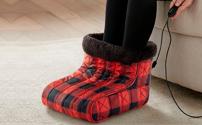 A Woman Using the Shavel Micro Flannel Heated Foot Warmer in Buffalo Checkered Color