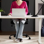 A Woman Working on the Smug Electric Height Adjustable Standing Desk