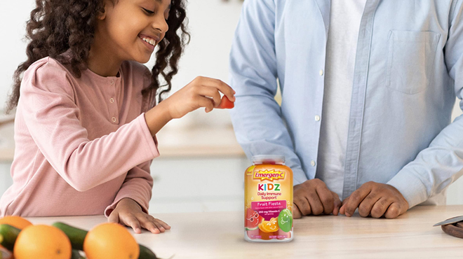 A girl holding a Emergen C Kidz Supplment