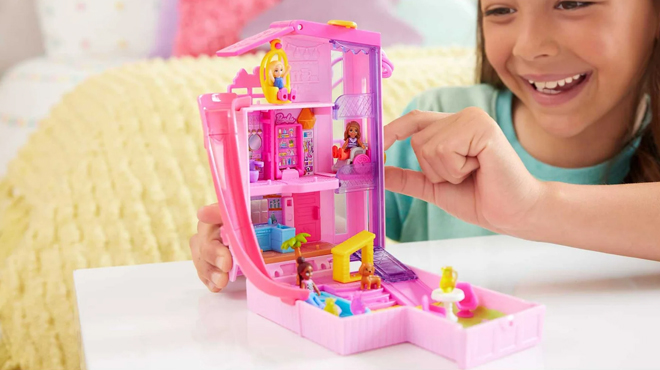 A girl playing with Polly Pocket Barbie Dreamhouse Playset