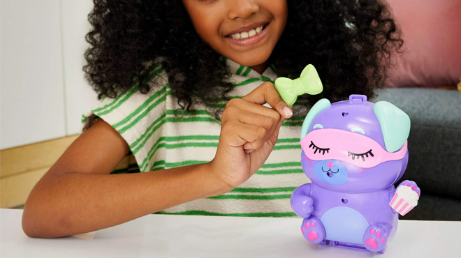 A girl playing with Polly Pocket Sleepover Puppy Compact Playset