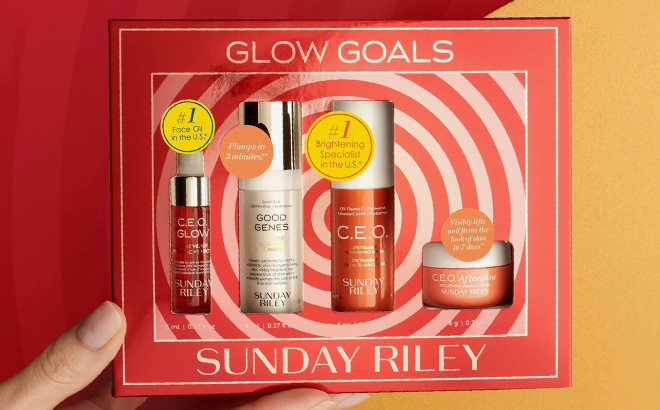 A hand holding Sunday Riley Glow Goals Kit