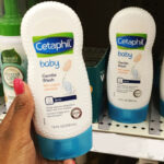 A person holding a Cetaphil Gentle Baby Body Wash 7 8 oz