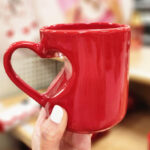 A person holding a Threshold 13 oz Stoneware Heart Handle Mug