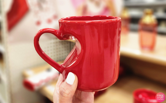 A person holding a Threshold 13 oz Stoneware Heart Handle Mug