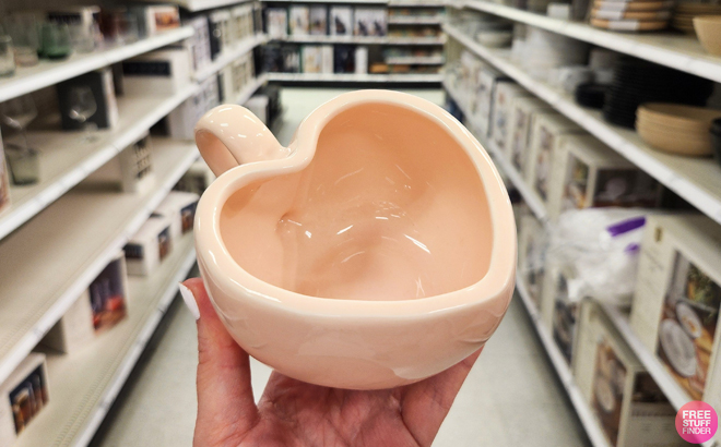 A person holding a Threshold 9 oz Stoneware Figural Latte Heart Mug