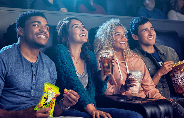 College Students Watching a Movie at a Theater and Laughing