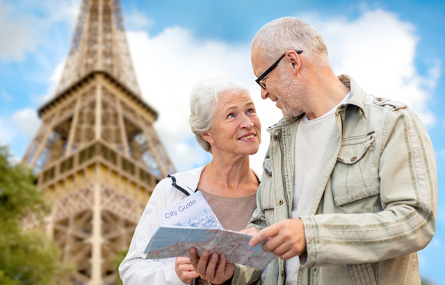 Senior Coupla Standing in Front of Eiffel Tower with a City Map in Hand