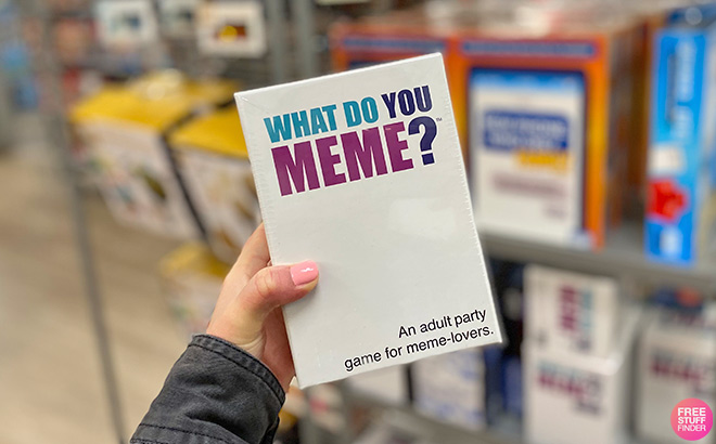 A Hand Holding What Do You Meme Board Game